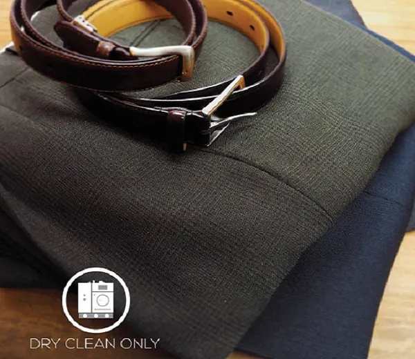 Folded wool garments and leather belts with a dry clean only label